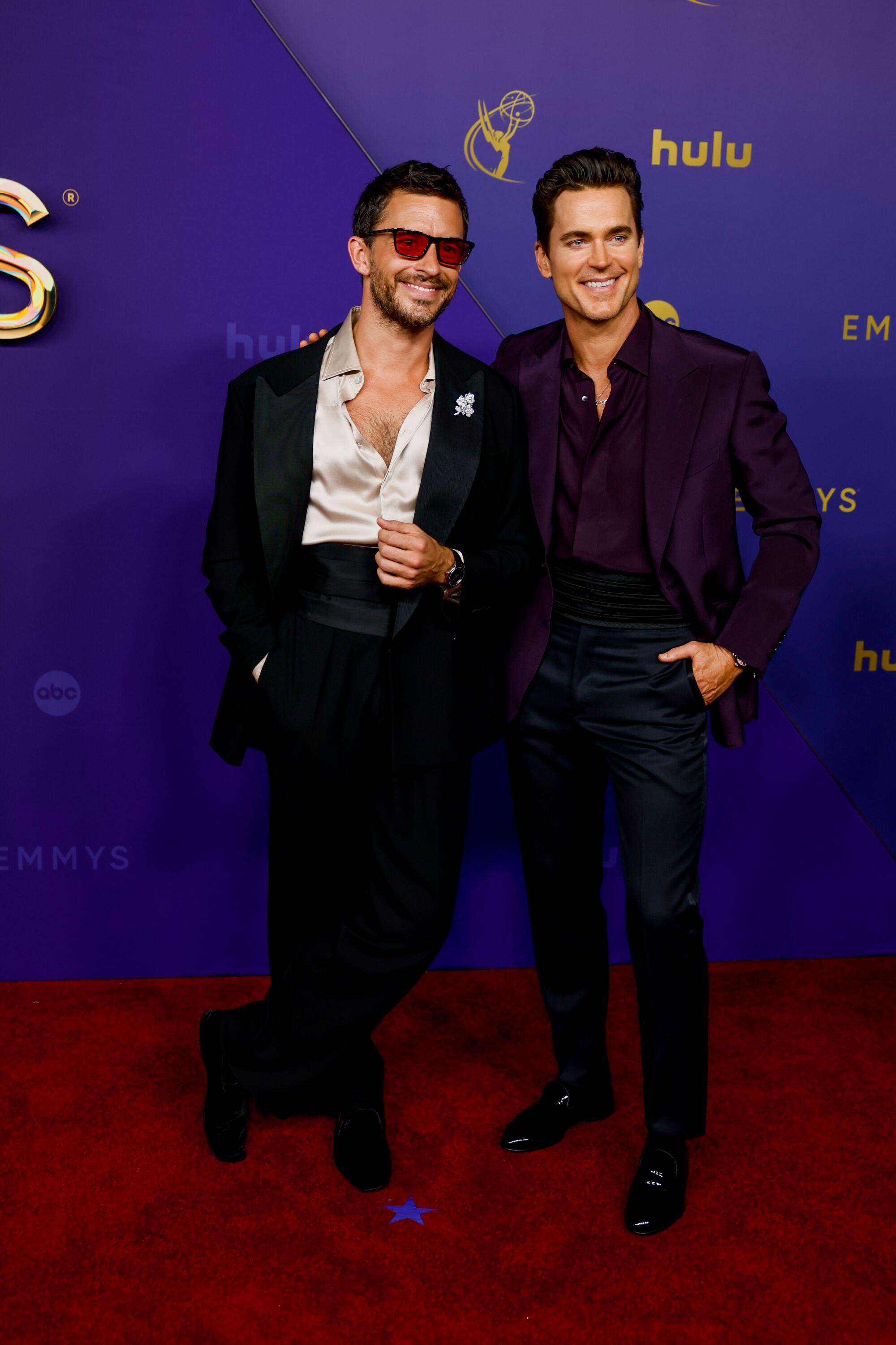 Jonathan Bailey and Matt Bomer smile on the red carpet.