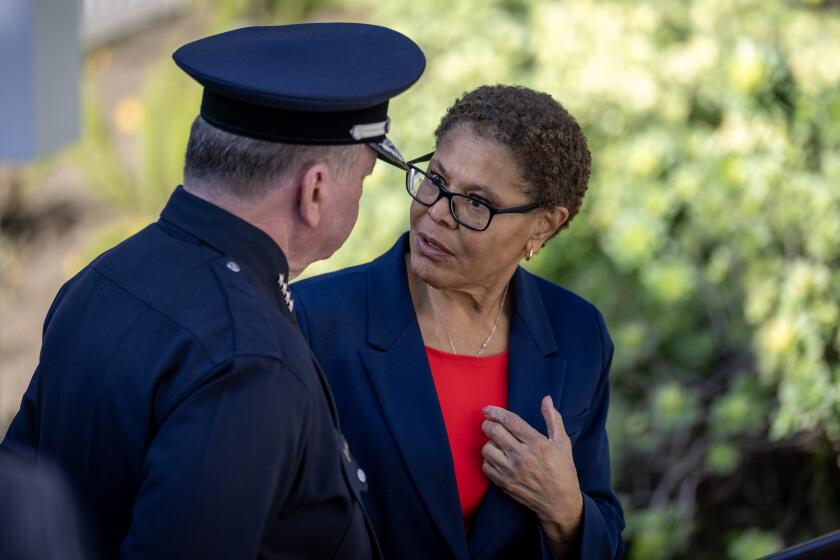Los Angeles, CA - January 7: Los Angeles Police Chief Jim McDonald, left, speaks with Los Angeles Mayor Karen Bass after a private ceremony where they remembers the fire victims with faith leaders, LAPD officers and city officials as flags were lowered outside City Hall to commemorate the one-year anniversary of the Eaton and Palisades fires in Los Angeles on Wednesday, Jan. 7, 2026. (Allen J. Schaben / Los Angeles Times)