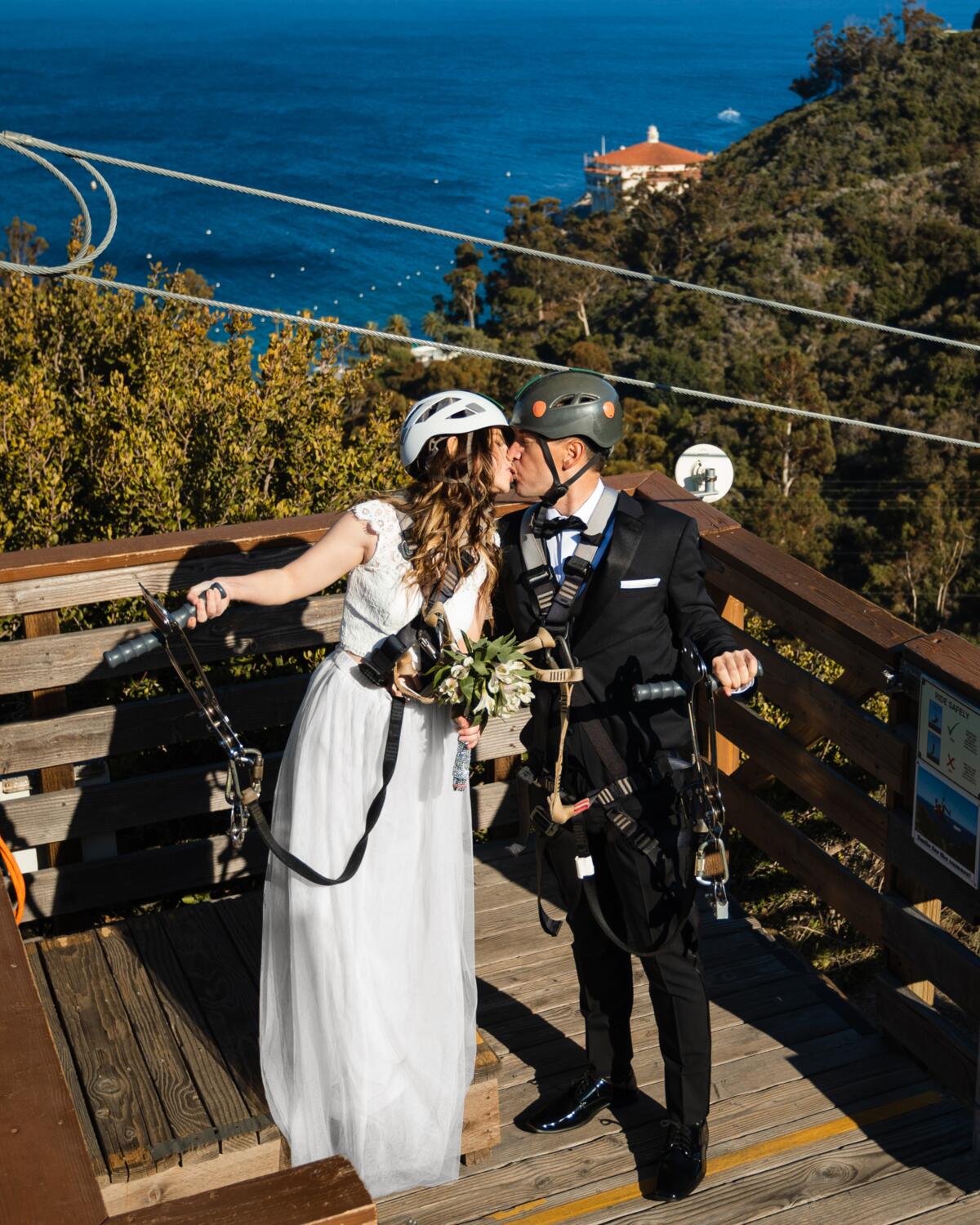 Bride and groom kissing on a zipline platform on Catalina Island.