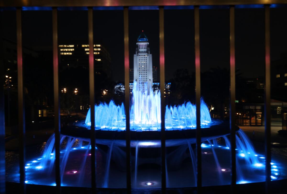 A view of LA City Hall bathed in blue light.