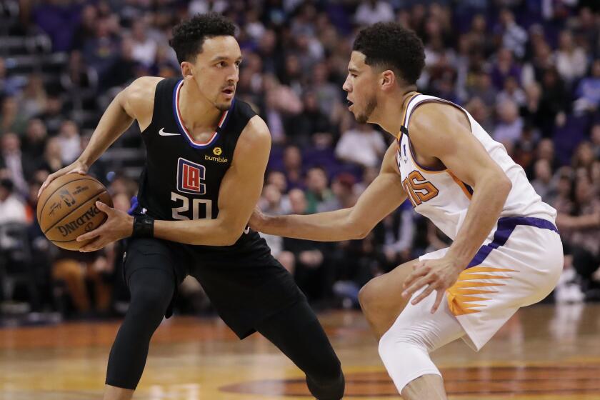 Los Angeles Clippers guard Landry Shamet (20) looks to pass as Phoenix Suns guard Devin Booker defends during the first half of an NBA basketball game, Wednesday, Feb. 26, 2020, in Phoenix. (AP Photo/Matt York)
