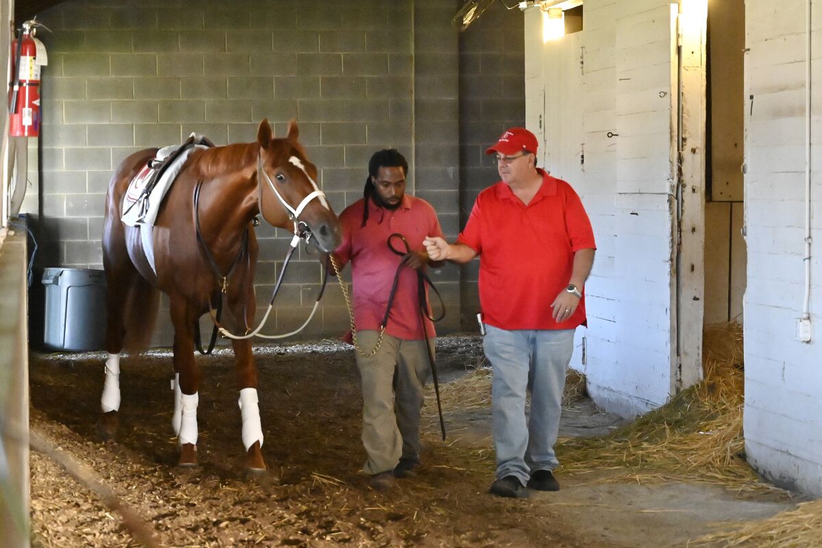 Eric Reed, right, trainer of Kentucky Derby winner Rich Strike, speaks with groom Jerry Dixon Jr.