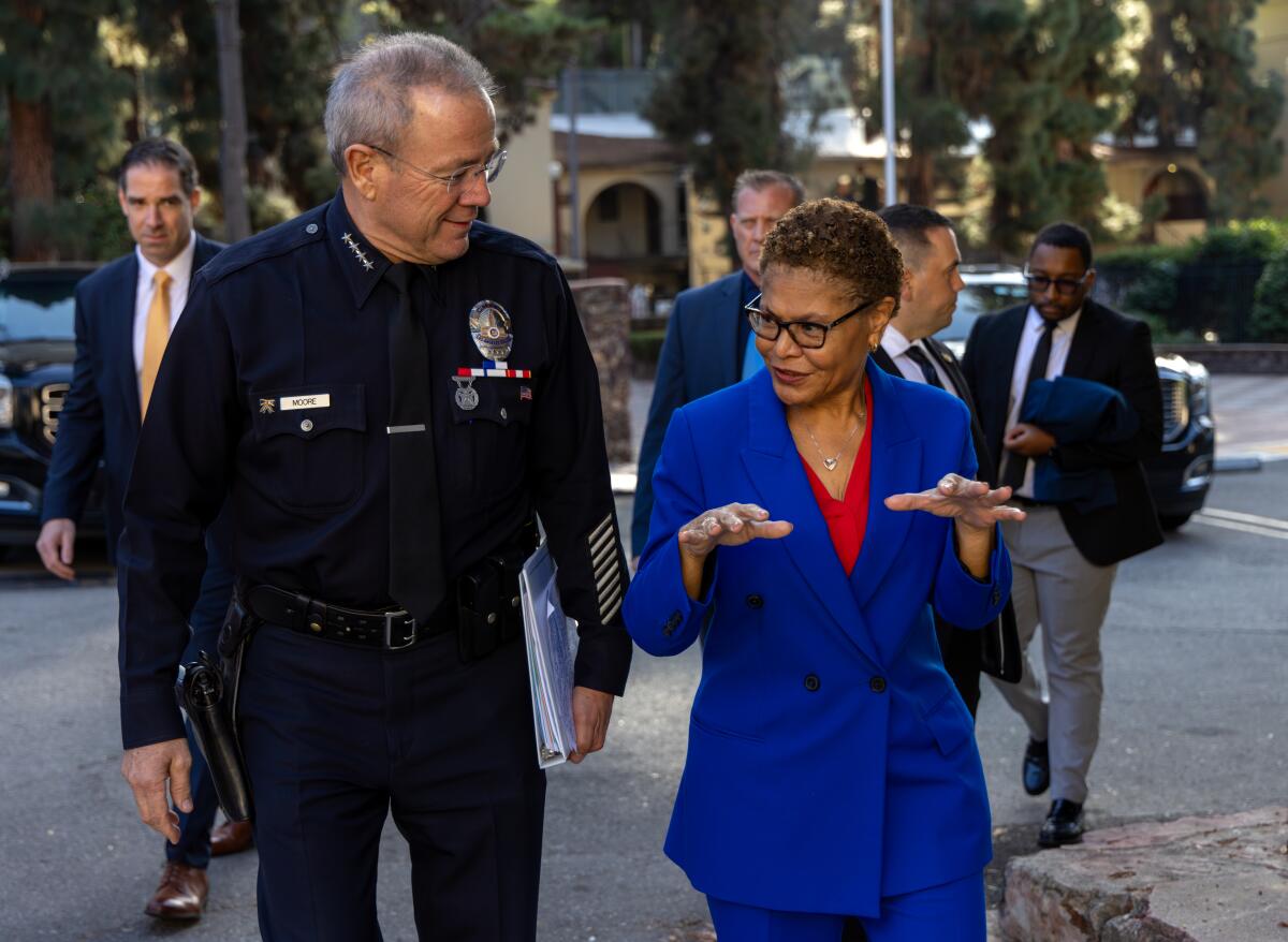 LAPD Chief Michel Moore, left, walks alongside Mayor Karen Bass at the Police Academy in December.