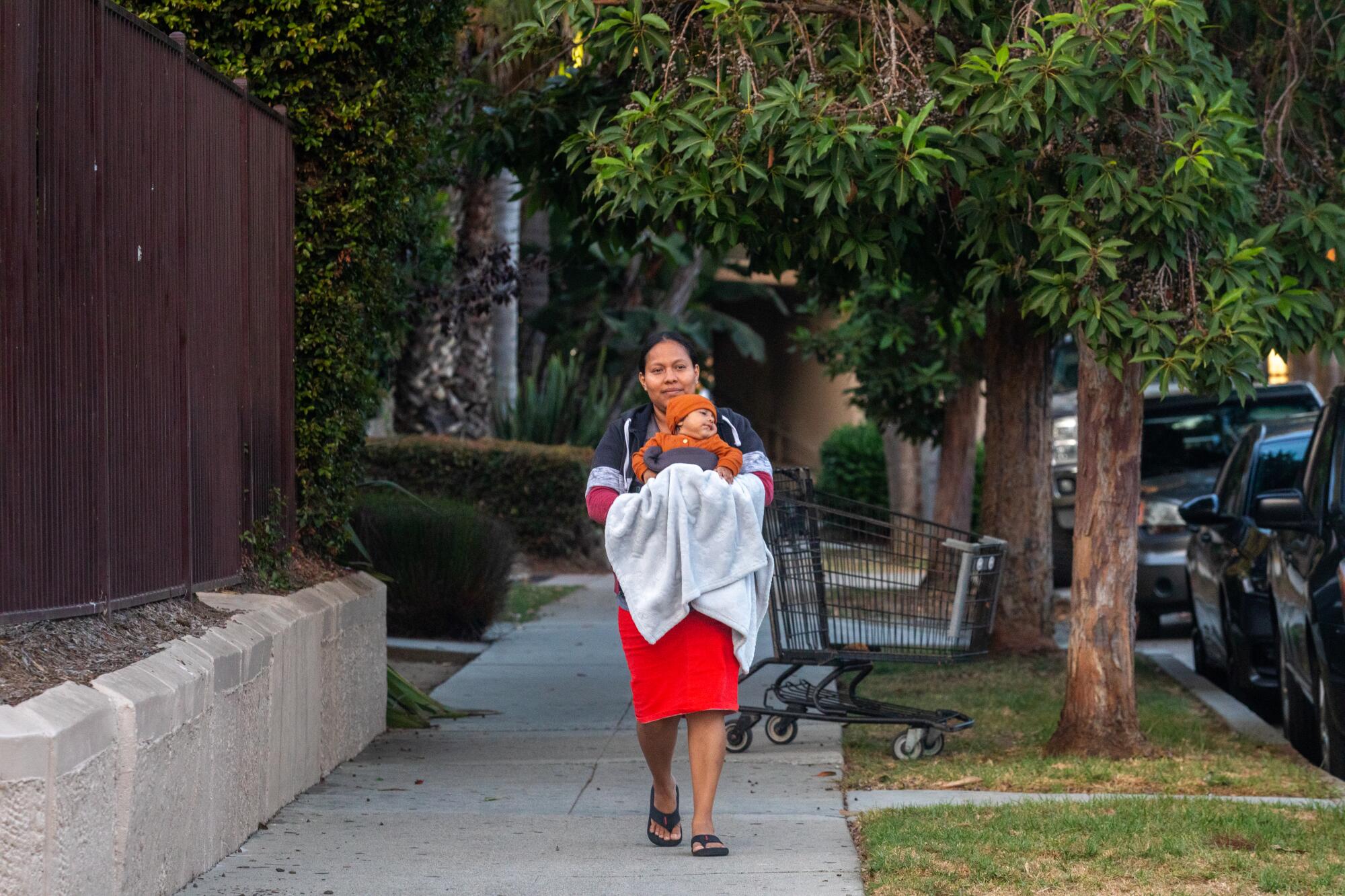 Rosario Palma, 28, carries  her 4-month-old son, Josue Bernal, near Bonhett Park