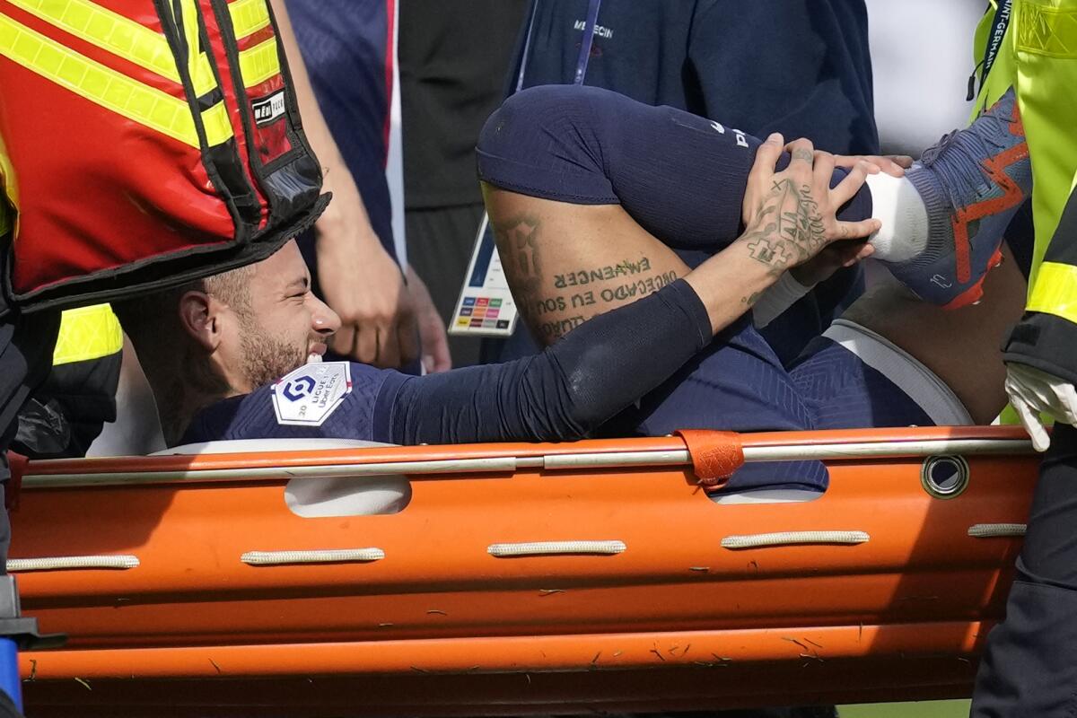 El delantero brasileño Neymar del Paris Saint-Germain sale lesionado durante el partido contra Lille 