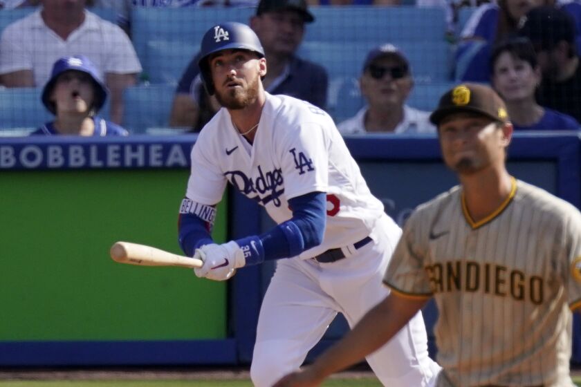 Los Angeles Dodgers' Cody Bellinger, left, runs to first as he hits a solo home run while San Diego Padres.