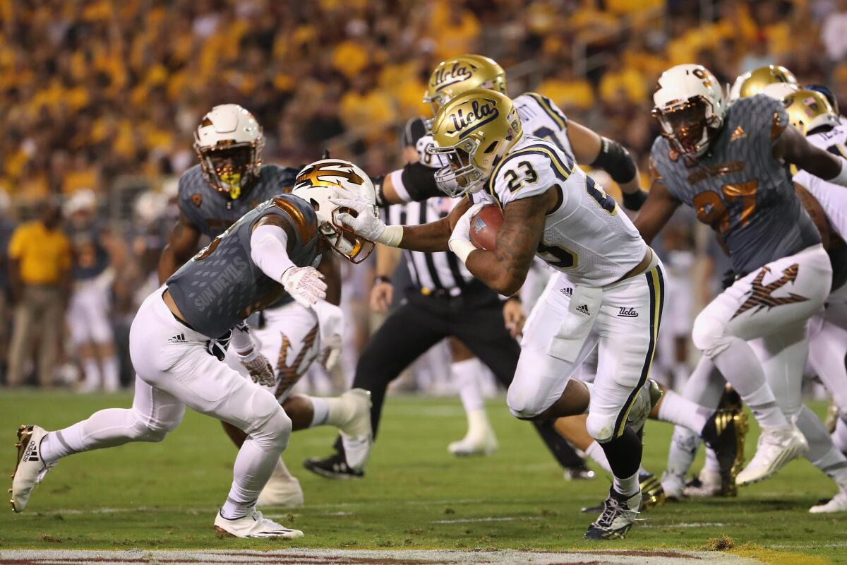 UCLA running back Nate Starks (23) looks for some room to run against Arizona State on Saturday night.