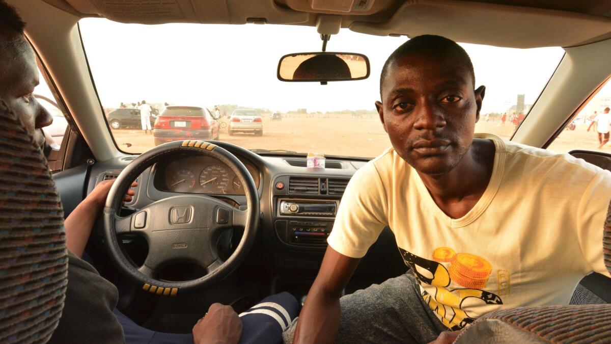 Driving instructor Muhammad Sabiu, right, with a student in northern Nigeria. “Of course, we do have some crashes,” he says.