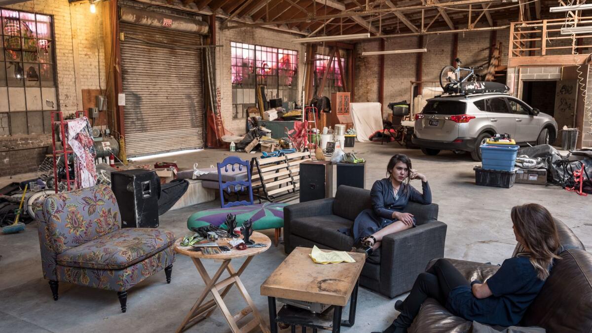 Misha Naiman, center, speaks with Tanya Rutherford at a warehouse space in West Oakland where they are trying to receive permitting from the city that would allow them to build separate rooms and other facilities.