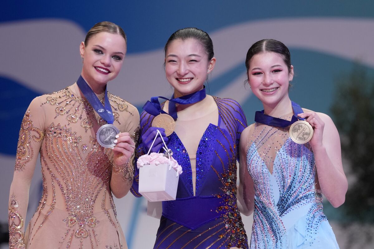 Loena Hendricks of Belgium, silver medal, left, Kaori Sakamoto of Japan, gold medal, center, and Alysa Liu of the U.S, bronze medal, celebrate during the women victory ceremony at the Figure Skating World Championships in Montpellier, south of France, Friday, March 25, 2022. (AP Photo/Francisco Seco)