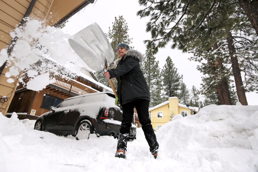 BIG BEAR LAKE, CA - FEBRUARY 28: Amblerlee Barden shovels snow after successive storms dumped several feet of snow blocking her driveway on Tuesday, Feb. 28, 2023 in Big Bear Lake, CA. (Brian van der Brug / Los Angeles Times)