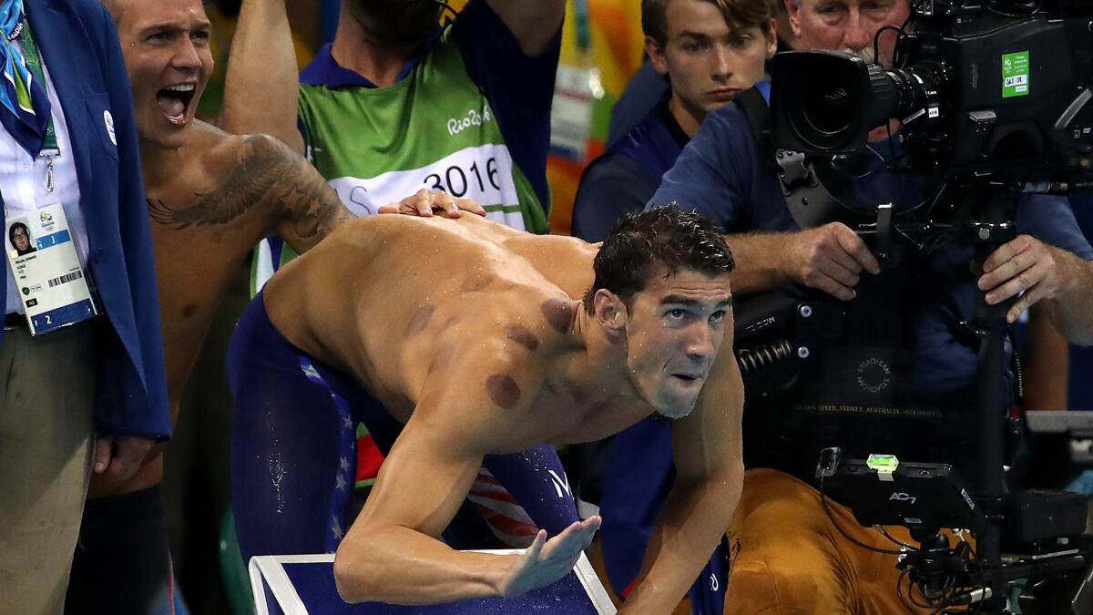 Michael Phelps encourages teammate Nathan Adrian to finish strong and seal the gold medal in the 400-meter freestyle relay on Sunday.