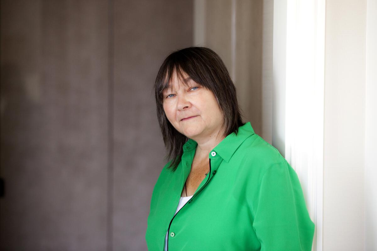 A portrait of a woman in a green button-down shirt.