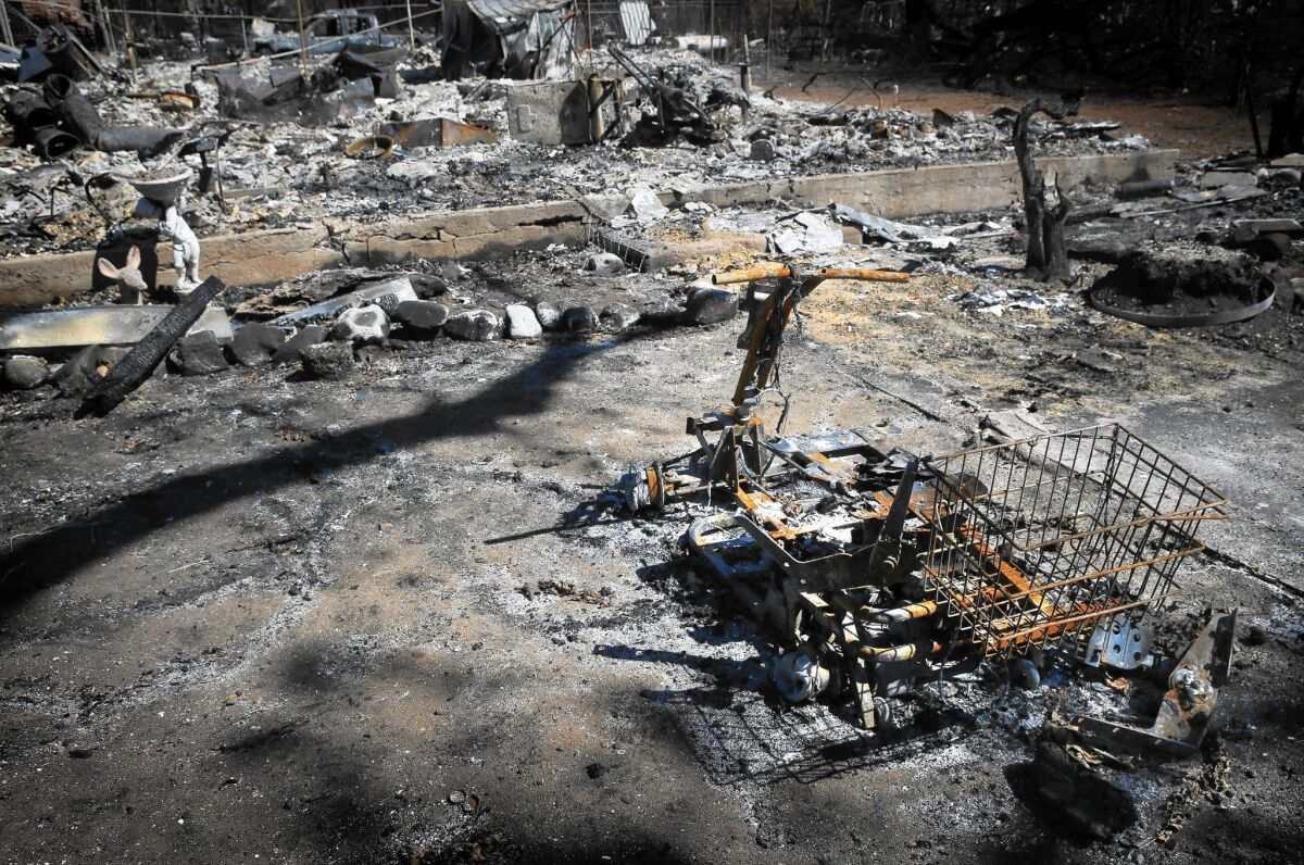 The charred remains an electric scooter sit outside a destroyed home after the Valley fire struck Middletown.