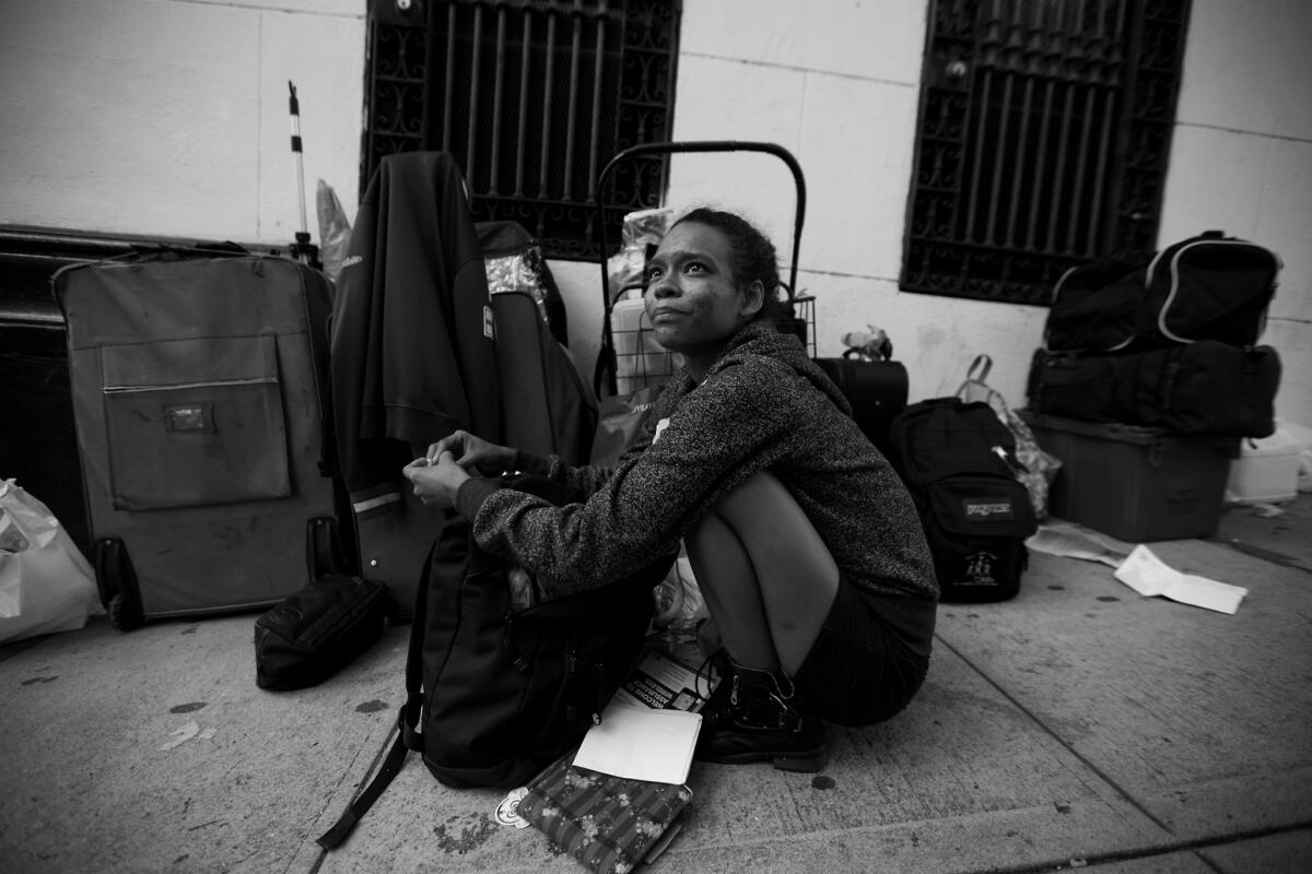 Shirley Velastegui, 22, sits next to her luggage near MacArthur Park. She says she has been homeless for a year and is a drug user.