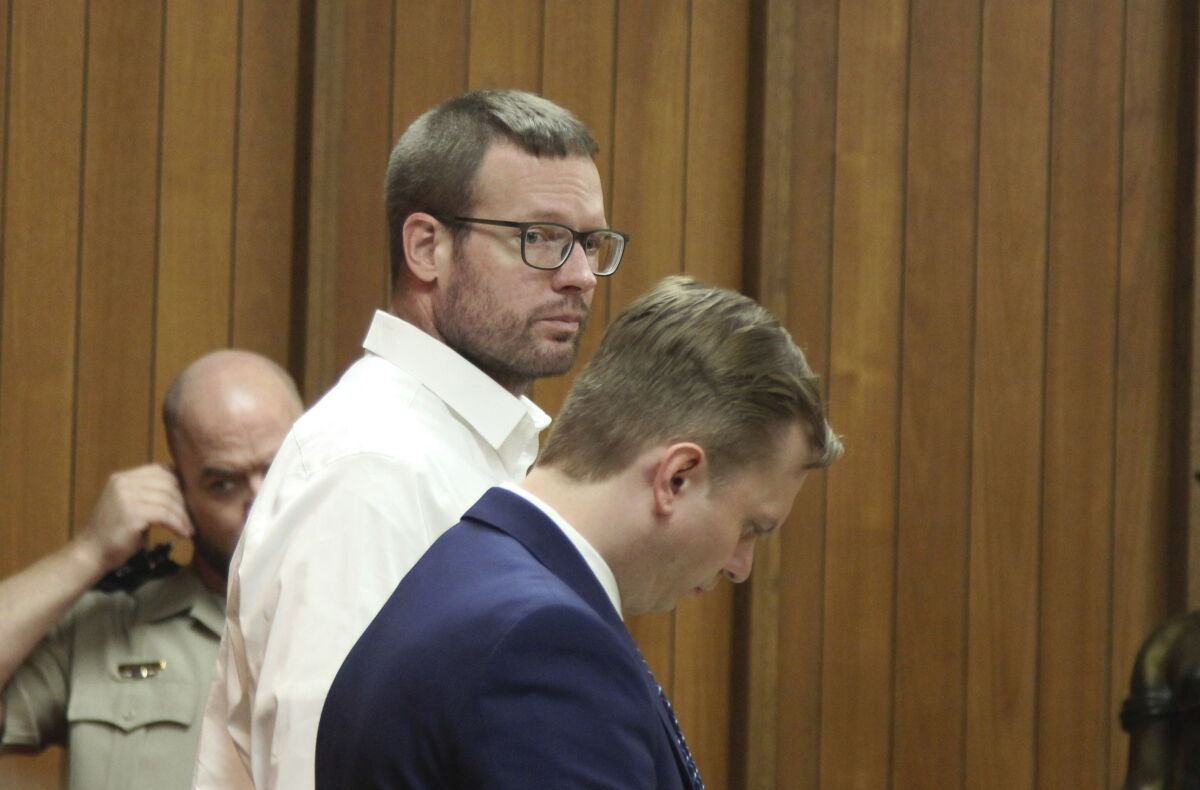 Michael Lang, left, stands with his defense attorney Konrad Kamizelich on Tuesday, May 10, 2022, in Webster City, Iowa. Lang is charged with first-degree murder in the April 2021 shotgun killing of Iowa State Patrol Sgt. Jim Smith at Lang’s home in Grundy Center. Smith, a 27-year patrol veteran, was shot as he led a team of officers into Lang’s home. (Jeff Reinitz/The Courier via AP)