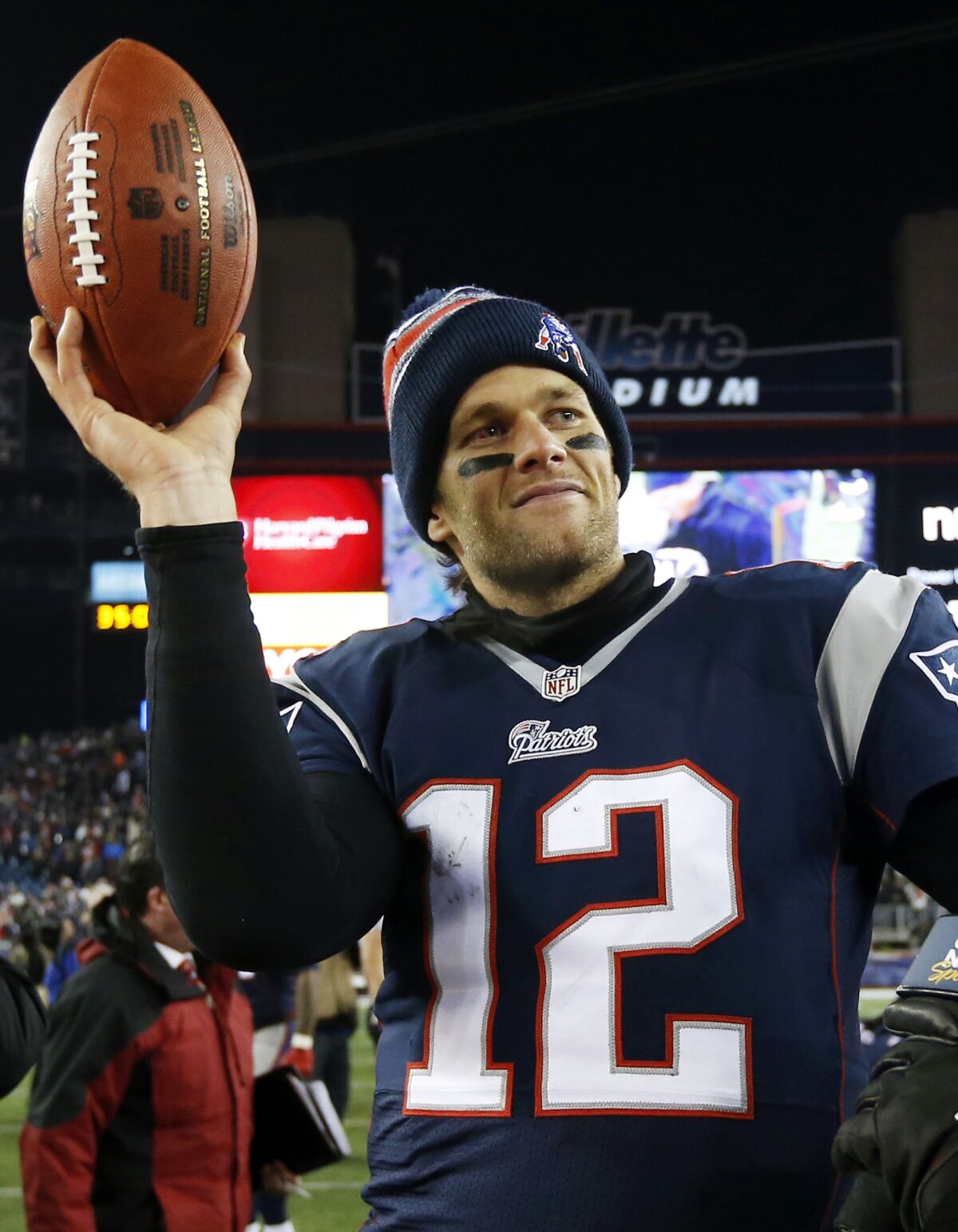 FILE - In this Jan. 10, 2015 photo, New England Patriots quarterback Tom Brady holds up the game ball after football game