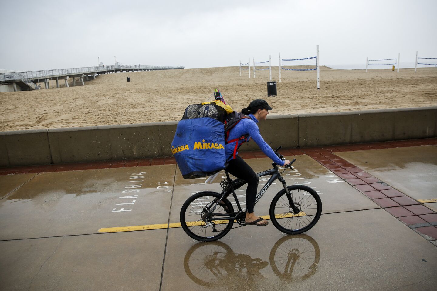 A biker at Hermosa Beach, where people were dealing with a lingering rainstorm.