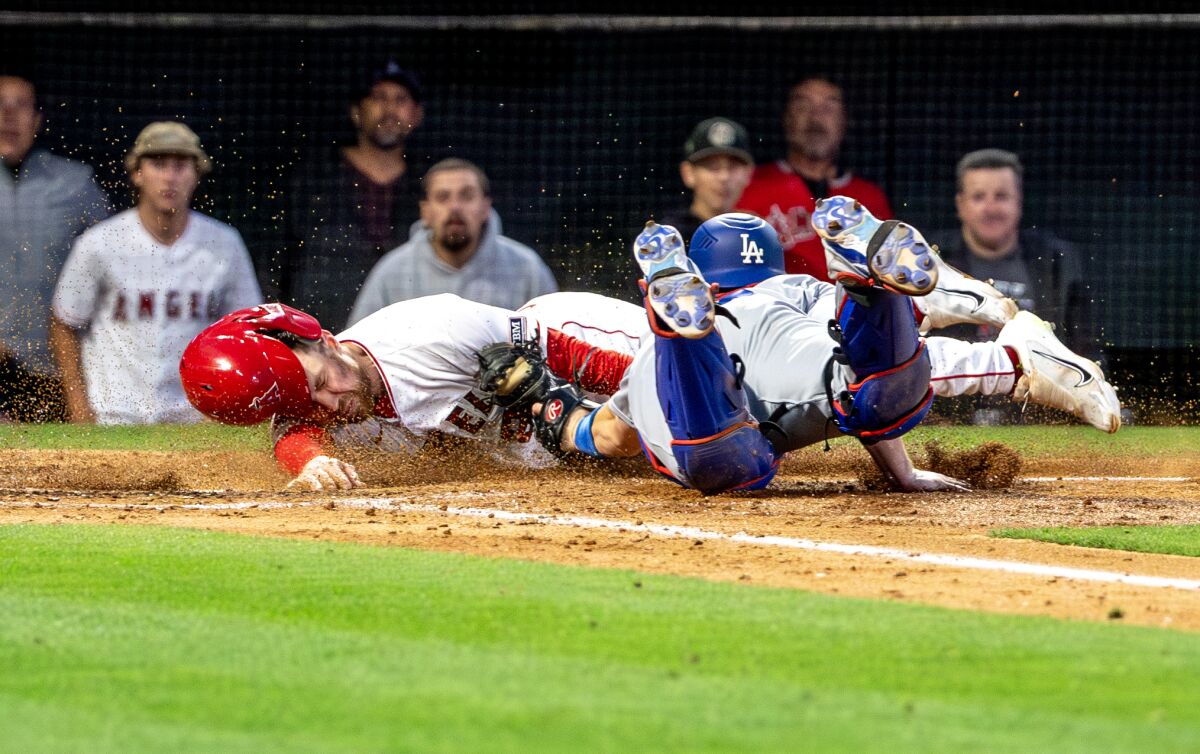 Angels second baseman Brandon Drury is tagged out at home plate by Dodgers catcher Will Smith.