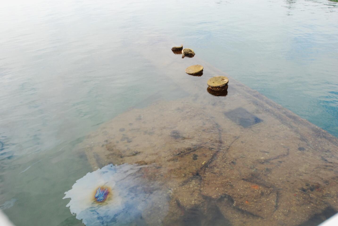 Oil seeps out of the sunken hull of the USS Arizona before a wreath laying ceremony at the memorial to the battleship in Pearl Harbor, Hawaii, Monday, Dec. 7, 2015. Before the wreath-laying, dozens of survivors and about 3,000 others gathered for a memorial ceremony marking the 74th anniversary of the Japanese attack. (AP Photo/Audrey McAvoy)