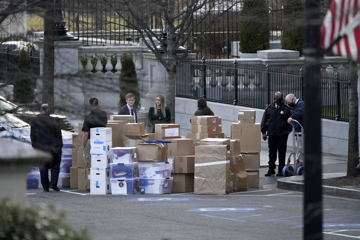 FILE - People wait for a moving van after boxes were moved out of the Eisenhower Executive Office building inside the White House complex, on Jan. 14, 2021, in Washington. The Justice Department has declined a request this week from the House oversight committee regarding the contents of records that former President Donald Trump took to his Florida residence after leaving the White House.(AP Photo/Gerald Herbert, File)