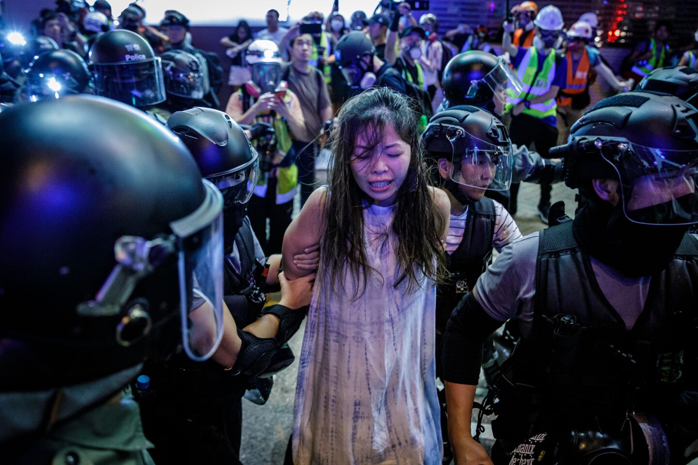 Police officers pepper spray and arrest a woman during a sweep for anti-government protesters on Nathan Road in the Mong Kok district in Hong Kong.