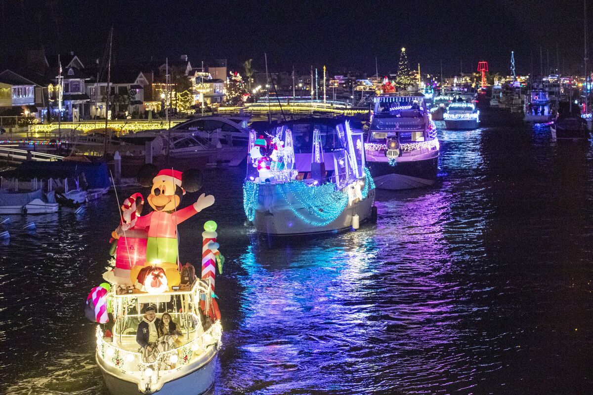 Nearly 100 boats decorated in lights participate in the Newport Beach Christmas Boat Parade at night
