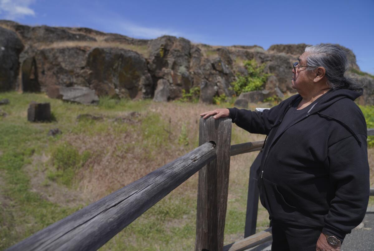Wilbur Slockish Jr., a river chief of the Klickitat Band of the Yakama Nation, looks at petroglyphs in Columbia Hills Historical State Park on Saturday, June 18, 2022, in Lyle, Wash. In the 1980s, Slockish served 20 months in federal prison on charges of poaching salmon from the Columbia River. He says he went to prison to fight for his people's right to practice their faith. (AP Photo/Jessie Wardarski)