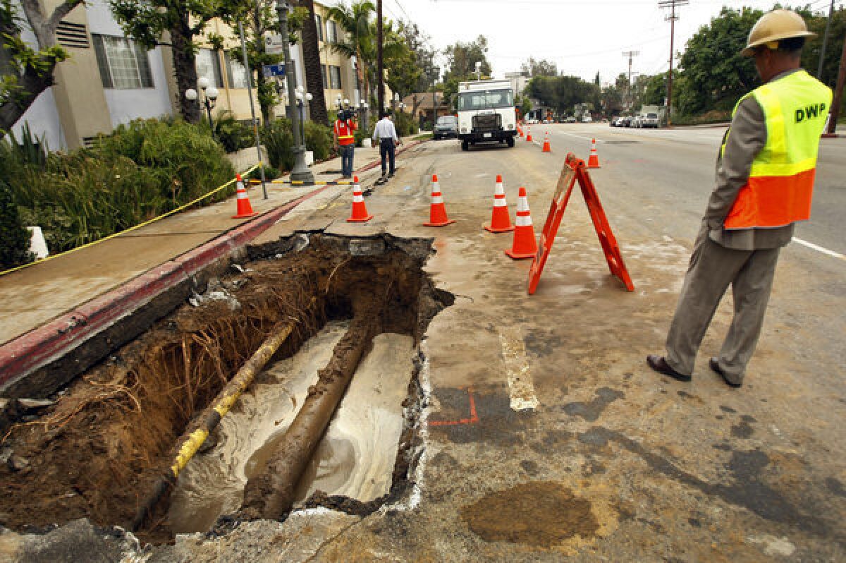 A Los Angeles Department of Water and Power supervisor at the scene of a water main break in Hollywood in May. The 12-inch cast iron pipe was installed in 1931.