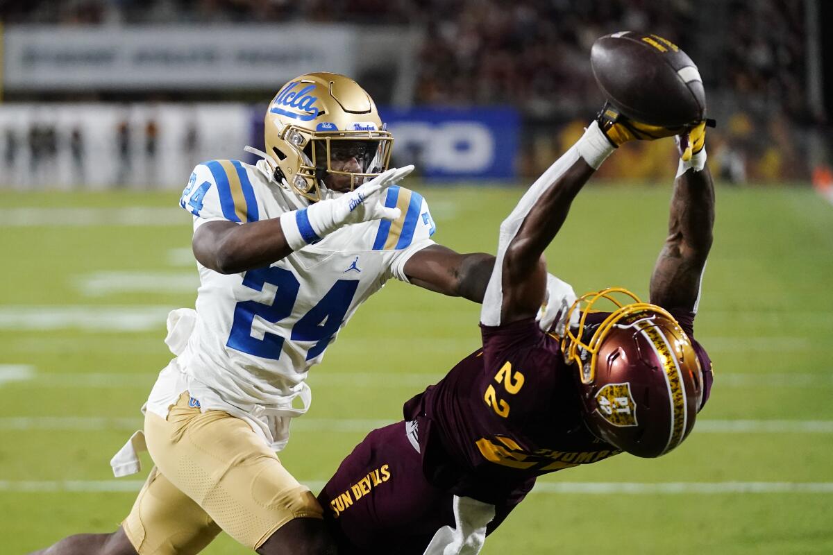 UCLA's Jaylin Davies shoves Arizona State's Bryan Thompson.