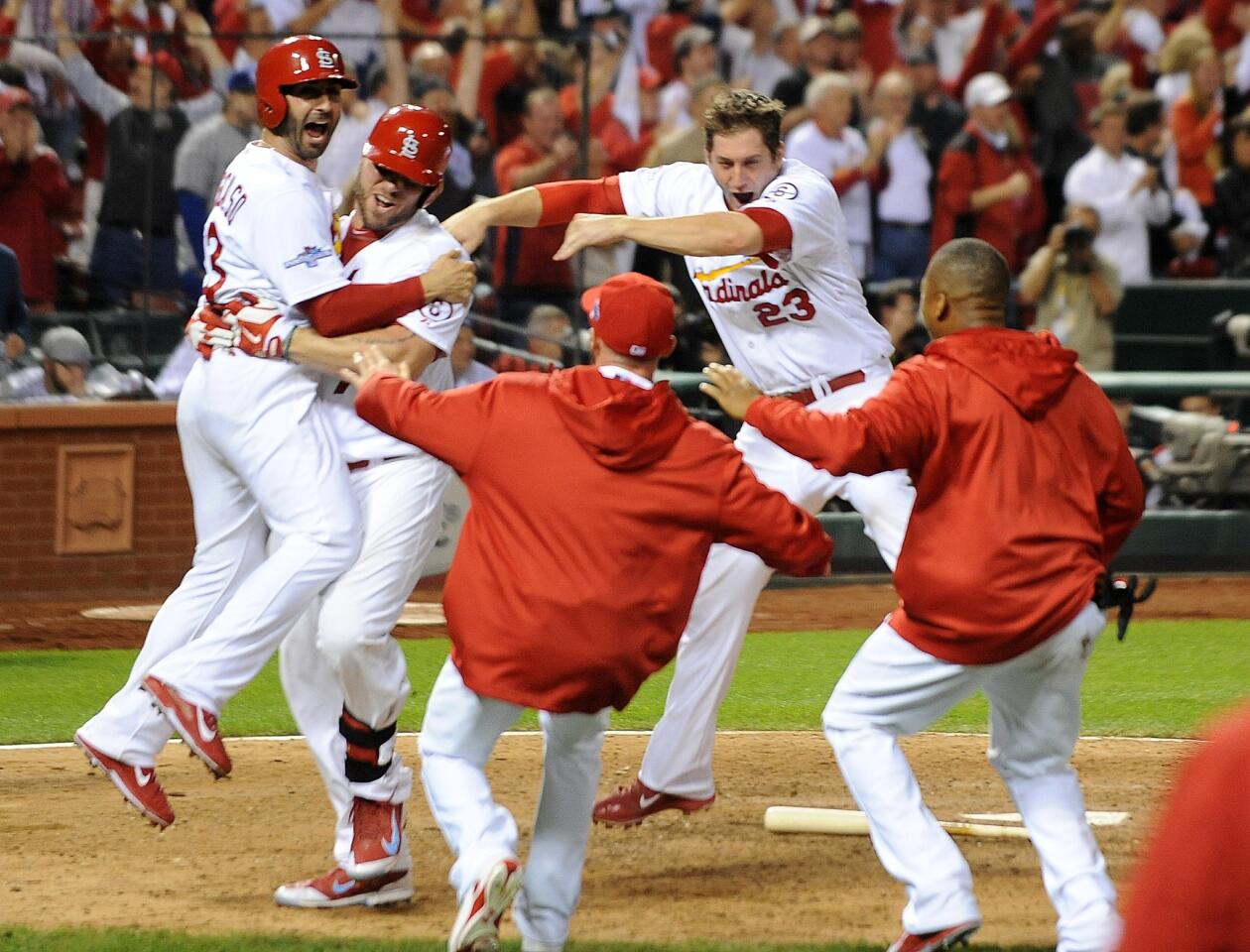 Cardinals teammates swarm Daniel Descalso after he scored the winning run against the Dodgers on a single by Carlos Beltran in the 13th inning of Game 1 on Friday night in St. Louis.