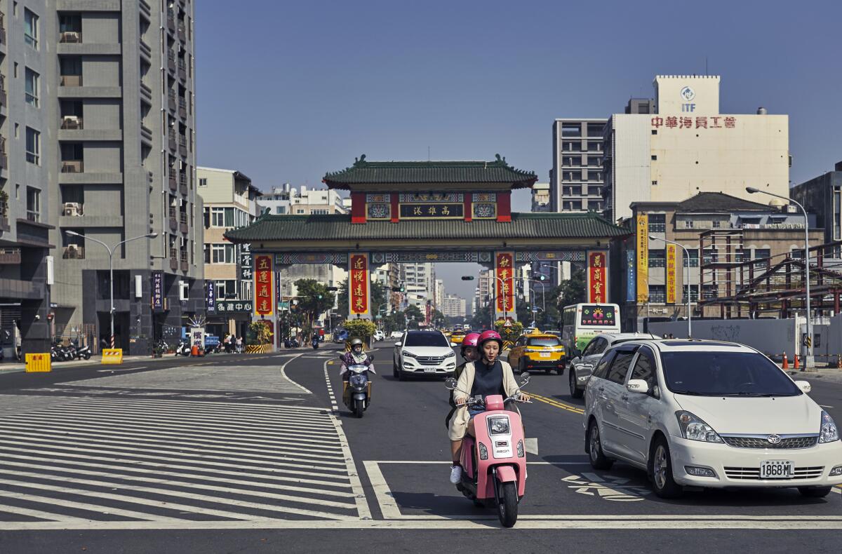 Scooters and motorists share the road in Kaoshiung, Taiwan, where a new mayor was recently elected on a platform of economic revitalization.