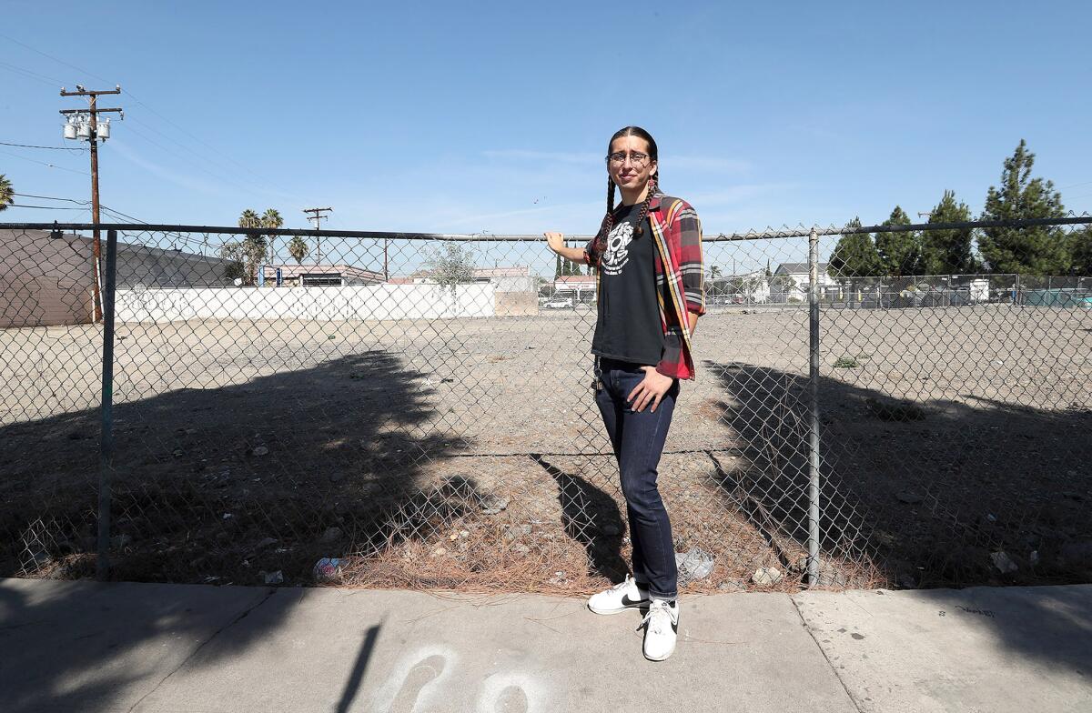 Patricia Flores, who leads Orange County Environmental Justice, stands next to a lot with possible lead in Santa Ana.