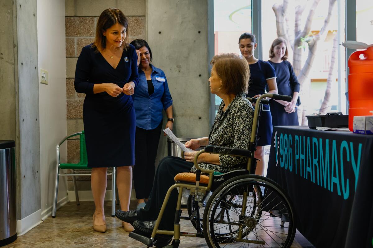 CDC Director Mandy Cohen speaks with a person in a wheelchair