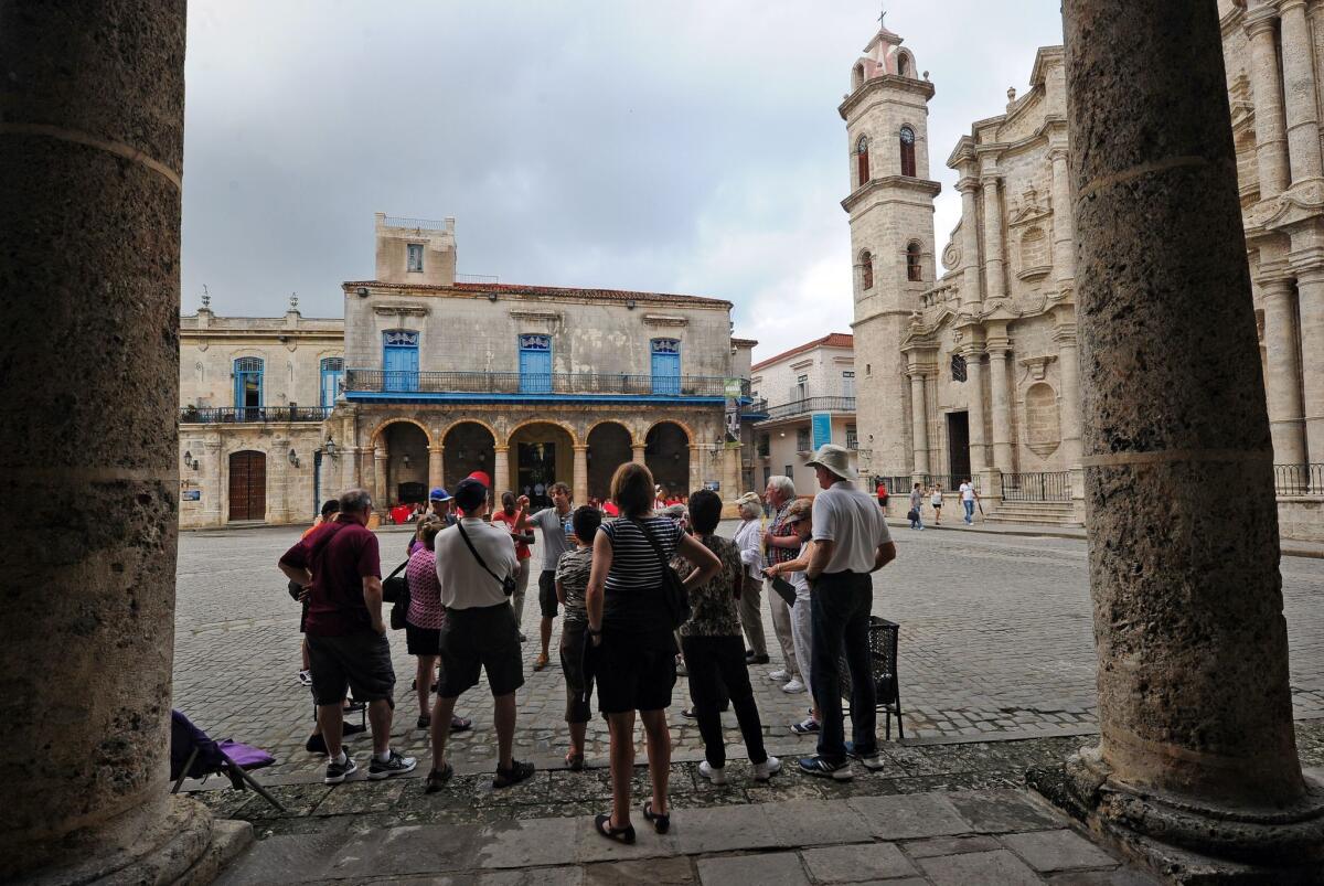Tourists visit the Old Havana section of Cuba's capital. The U.S. further eased travel and trade restrictions with Cuba on Tuesday.