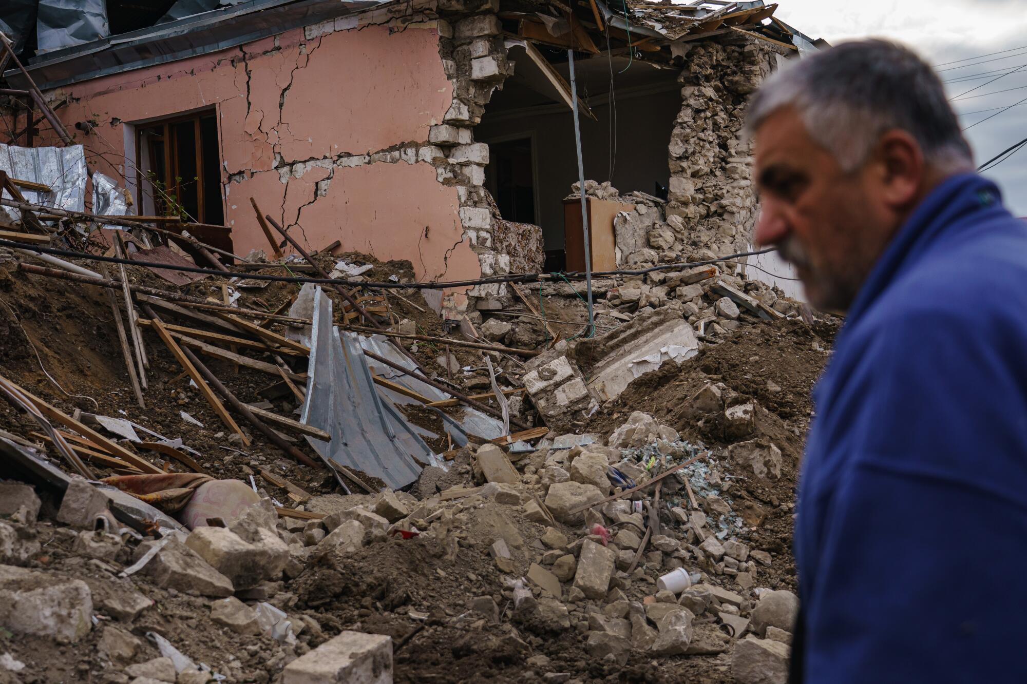 David Safaryan, 63, looks over the rubble of a destroyed home after a military strike in a residential neighborhood.