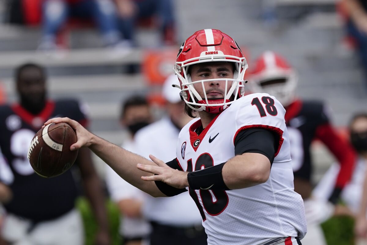 FILE - Georgia quarterback JT Daniels (18) throw a pass in the first half during Georgia's spring NCAA college football game in Athlens, Ga., in this Saturday, April 17, 2021, file photo. Monken believes his Georgia offense is “just so further ahead” than a year ago as it enters its first full season with JT Daniels at quarterback. The offense thrived in the Bulldogs' 4-0 finish after Daniels took over as the starter last season. Now, the continuity provided by Monken's second season as offensive coordinator and Daniels' return has fueled No. 5 Georgia's championship hopes for 2021. (AP Photo/John Bazemore, File)