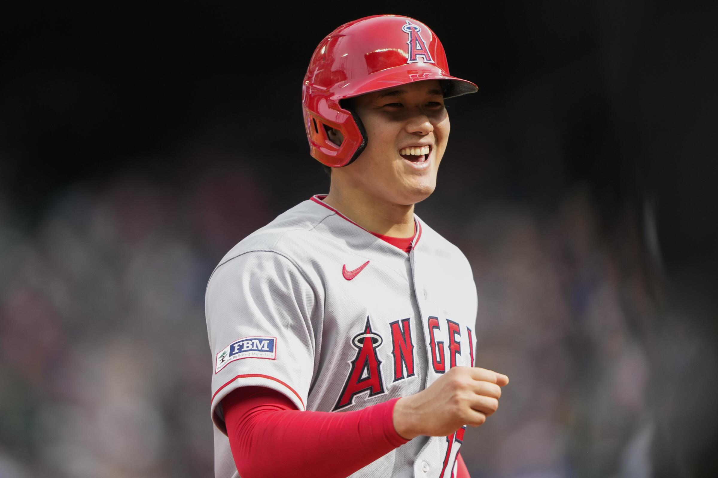 Angels' Shohei Ohtani smiles as he returns to the dugout after the seventh inning against the Seattle Mariners.