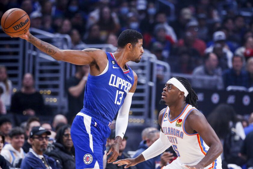 Los Angeles Clippers forward Paul George (13) is defended by Oklahoma City Thunder guard Luguentz Dort (5) during the first half of an NBA basketball game Tuesday, March 21, 2023, in Los Angeles. (AP Photo/Ringo H.W. Chiu)