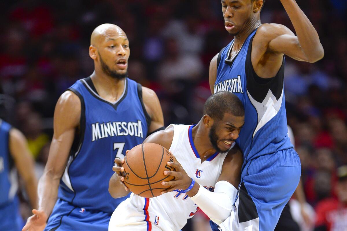 Clippers point guard Chris Paul is double teamed by Timberwolves forwards Adreian Payne (3) and Andrew Wiggins, right, in the second half.