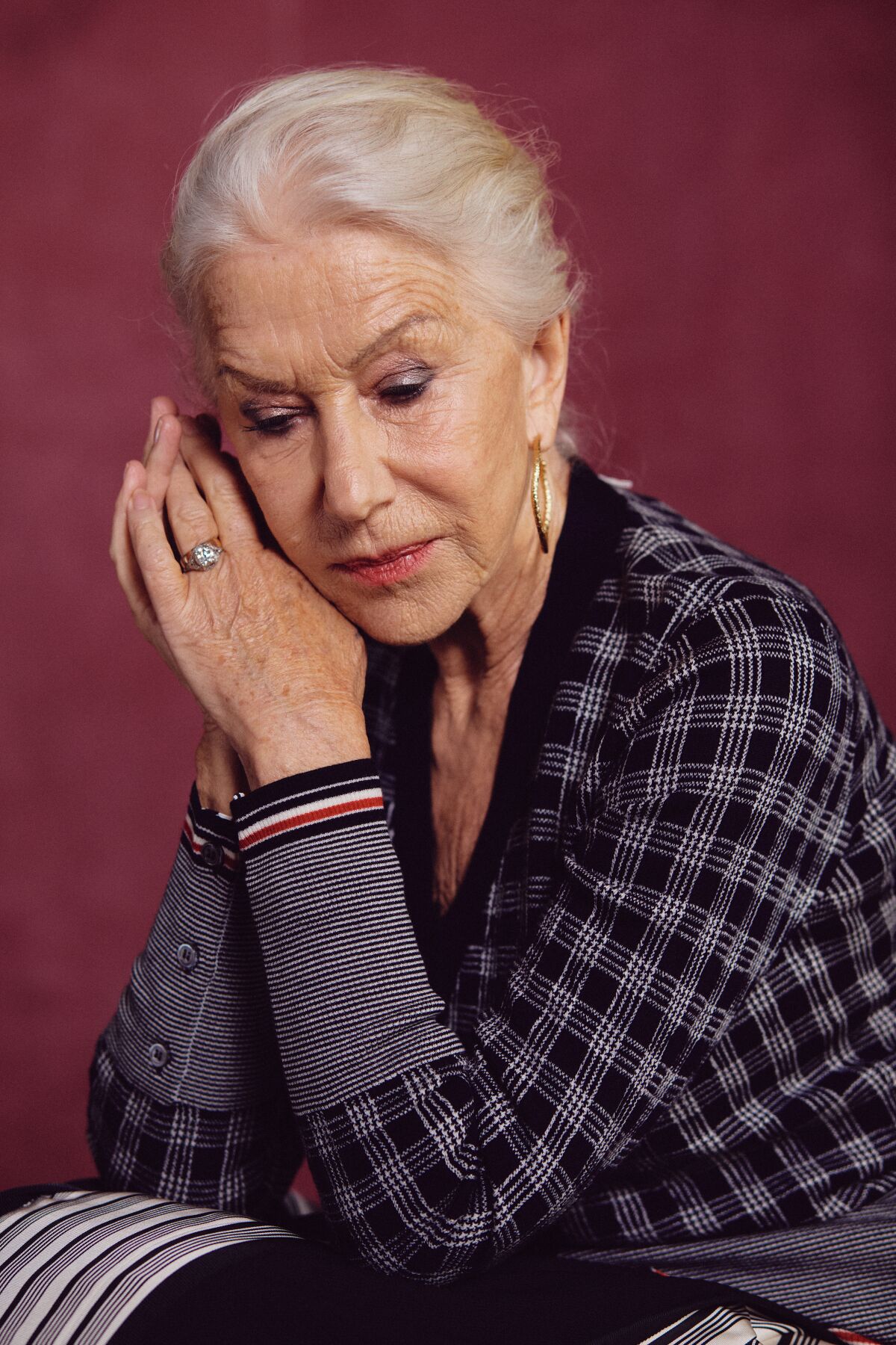 Helen Mirren rests her elbows and casts her eyes down for a portrait.