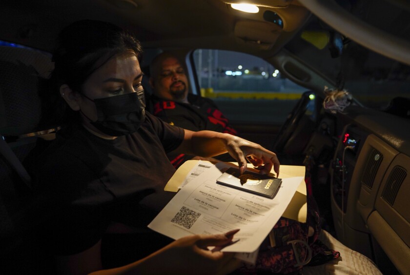 Flor Rios, 32, shows her proof of vaccination. She waited until midnight to cross at the San Ysidro Port of Entry