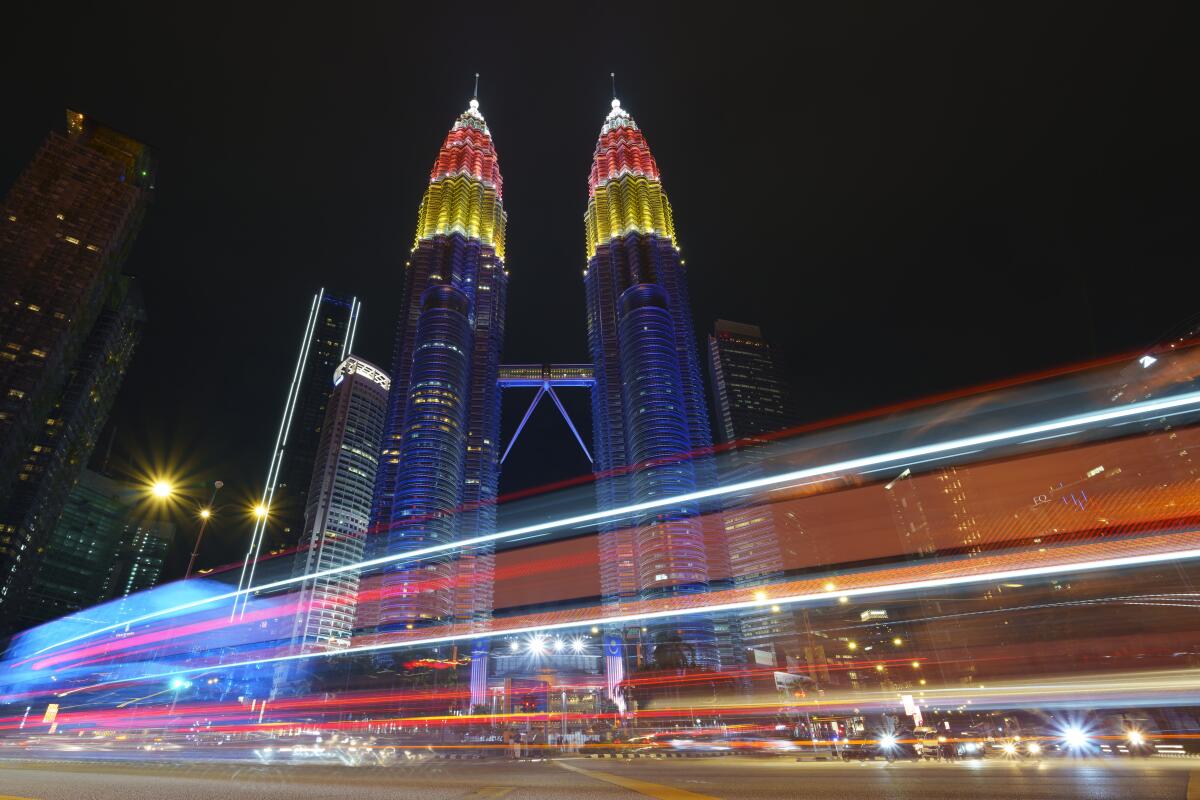 Petronas Twin towers decorated with colour lights during the 64th National Day celebrations to commemorate independence of Malaysia from British colonial rule, in Kuala Lumpur, Malaysia, Tuesday, Aug. 31, 2021. (AP Photo/Vincent Thian)
