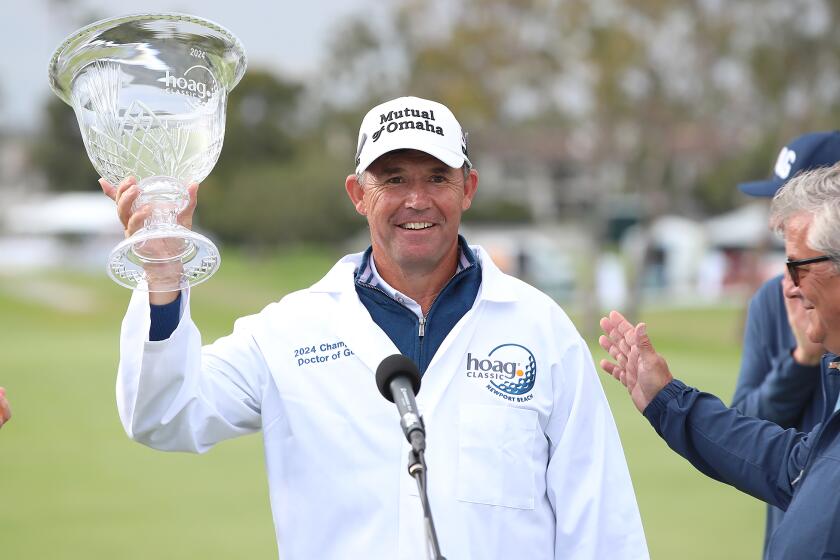 Wearing the 2024 Doctor of Golf jacket, Champion Padraig Harrington raises the trophy the after winning the Hoag Classic during final round, Sunday.