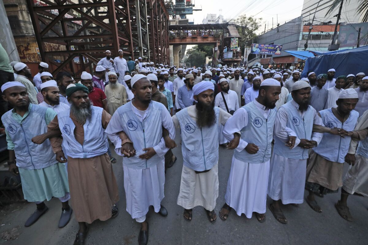 Muslims lock hands during a protest over an alleged insult to Islam, outside the country’s main Baitul Mukarram Mosque in Dhaka, Bangladesh, Saturday, Oct. 16, 2021. Thousands of Muslims protested in Bangladesh’s capital on Saturday for what they perceived as an image insulting Islam that had gone viral over social media. About 10,000 Muslims joined a peaceful protest under the banner of Islami Andolon Bangladesh as they took to the streets outside the country’s main Baitul Mukarram Mosque in downtown Dhaka. (AP Photo/Abdul Goni)