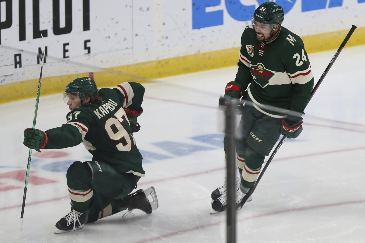 Minnesota Wild's Kirill Kaprizov (97) celebrates on the ice with Matt Dumba (24) after scoring a goal during the third period of the team's NHL hockey game against the Vegas Golden Knights on Wednesday, March 10, 2021, in St. Paul, Minn. Minnesota won 4-3. (AP Photo/Stacy Bengs)