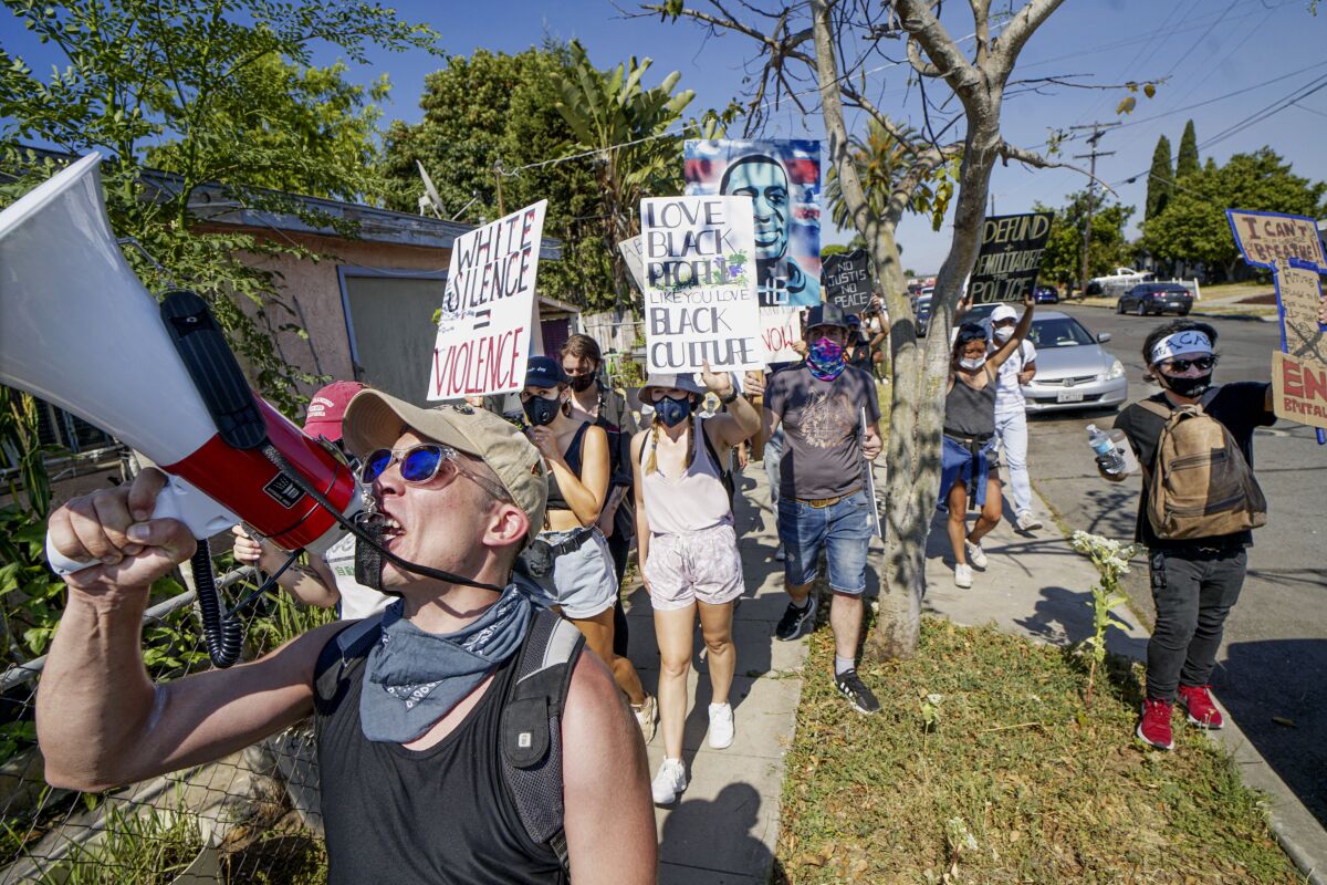 Demonstrators march down Landis Street in City Heights