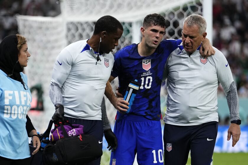 Christian Pulisic of the United States is helped off the pitch after suffering an injury during the World Cup group B soccer match between Iran and the United States at the Al Thumama Stadium in Doha, Qatar, Tuesday, Nov. 29, 2022. (AP Photo/Manu Fernandez)