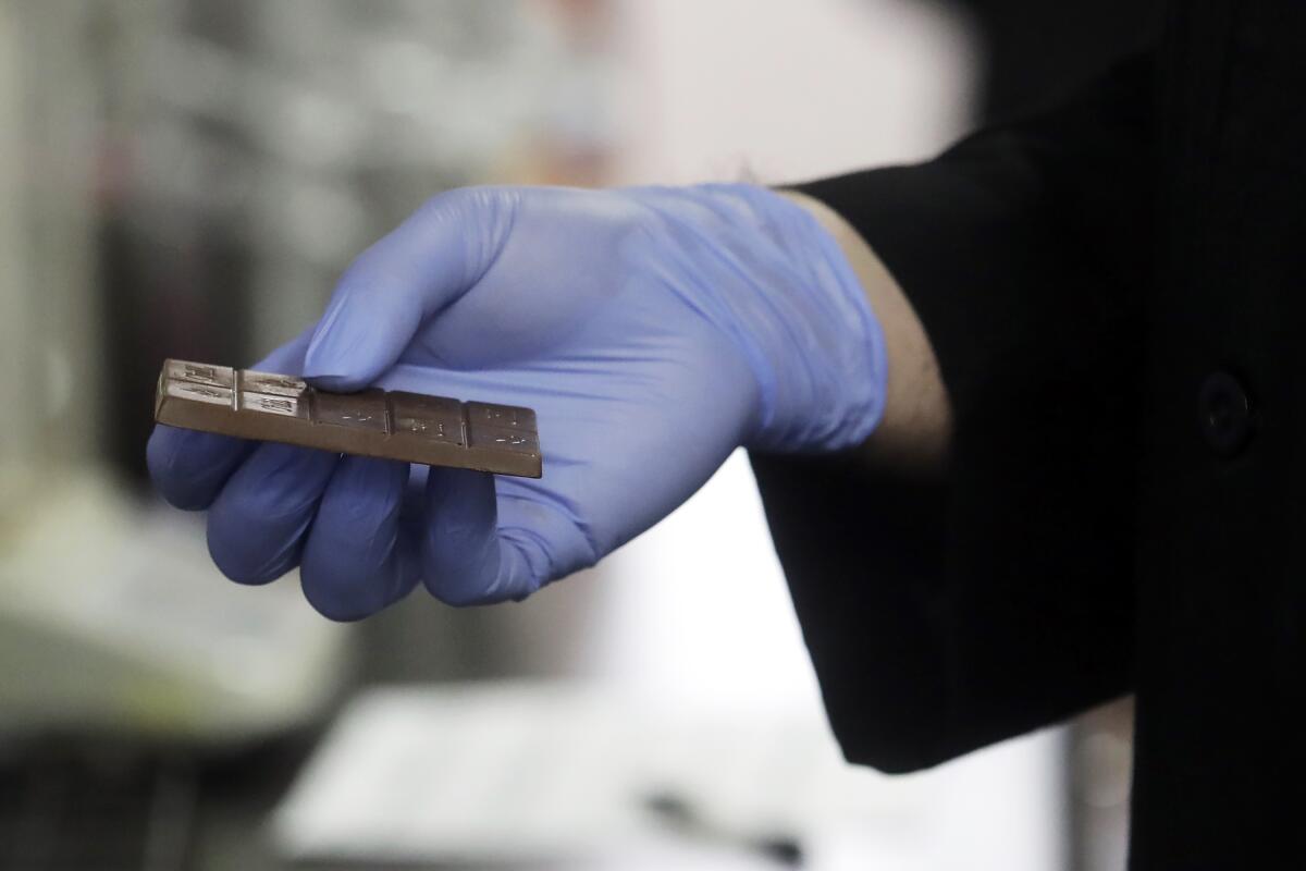 Chemist David Dawson holds a cannabis-infused chocolate bar as he demonstrates testing for THC and other chemicals at CW Analytical Laboratories in Oakland on Aug. 16.