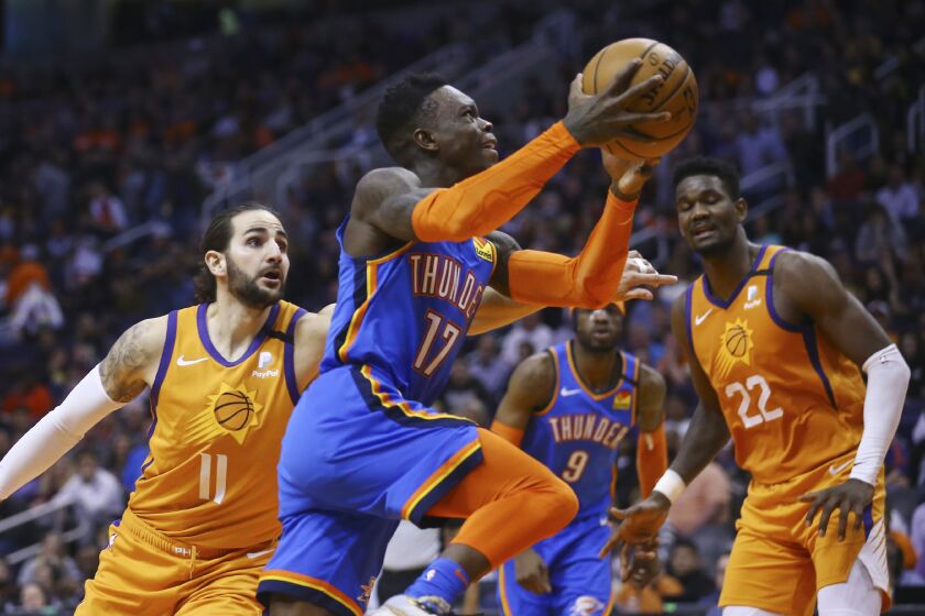 FILE - Oklahoma City Thunder guard Dennis Schroder (17) drives past Phoenix Suns guard Ricky Rubio (11) as Suns center Deandre Ayton (22) and Thunder center Nerlens Noel (9) watch during the first half of an NBA basketball game in Phoenix, in this Friday, Jan. 31, 2020, file photo. Teams may begin making trades Monday, according to a memo sent to teams and obtained early Sunday, Nov. 15, 2020, by The Associated Press. And the first deal known to be tentatively agreed upon would send guard Dennis Schröder from Oklahoma City to the champion Los Angeles Lakers for Danny Green and the No. 28 pick in Wednesday’s draft, a person with knowledge of that agreement told the AP. (AP Photo/Ross D. Franklin, File)